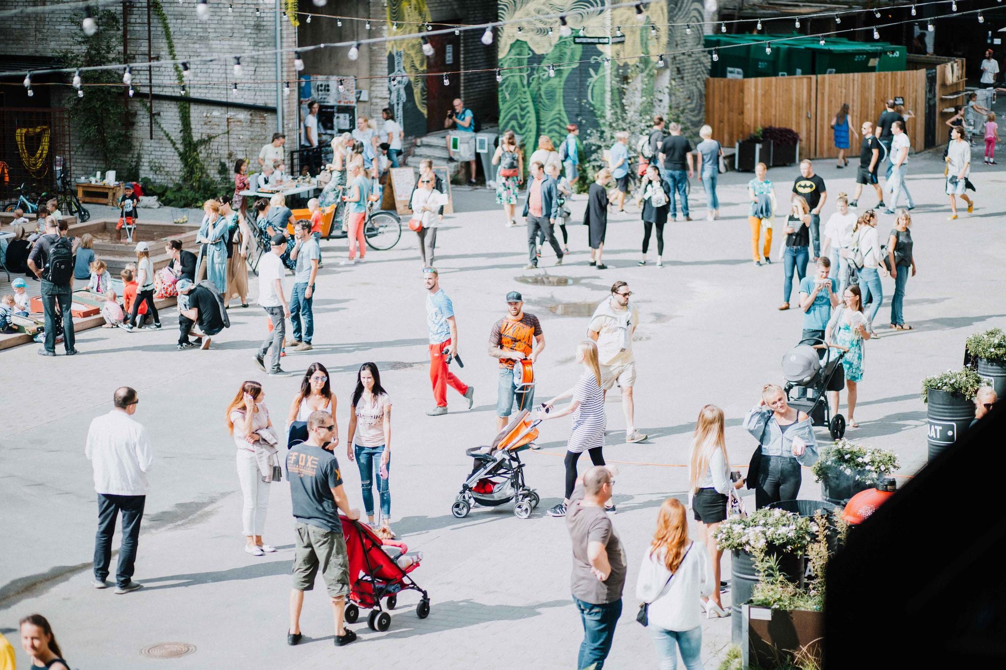 Inimesed jalutavad Aparaaditehase hoovis suvepäeval